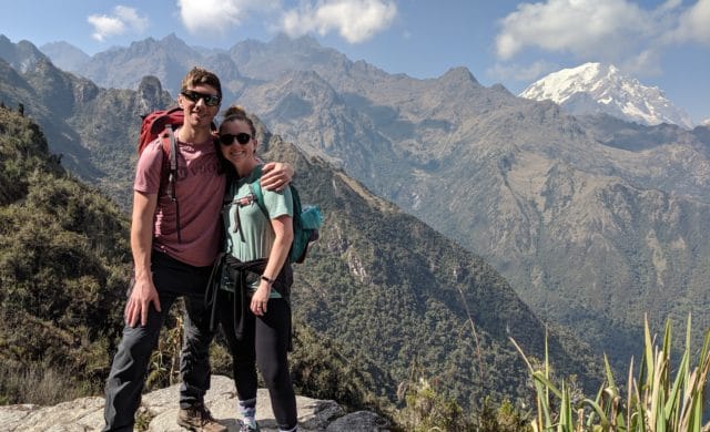 Male and female taking picture hiking on mountain