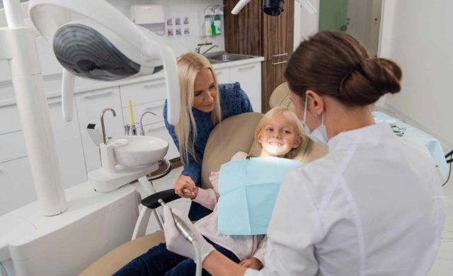 Daughter and mom receiving dental treatment from a family dentist