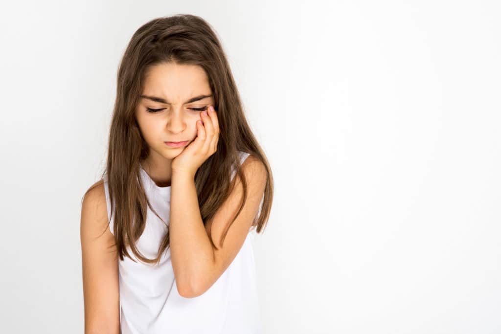 Portrait Of Young Girl Suffering With a chipped tooth