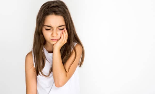 Portrait Of Young Girl Suffering With a chipped tooth