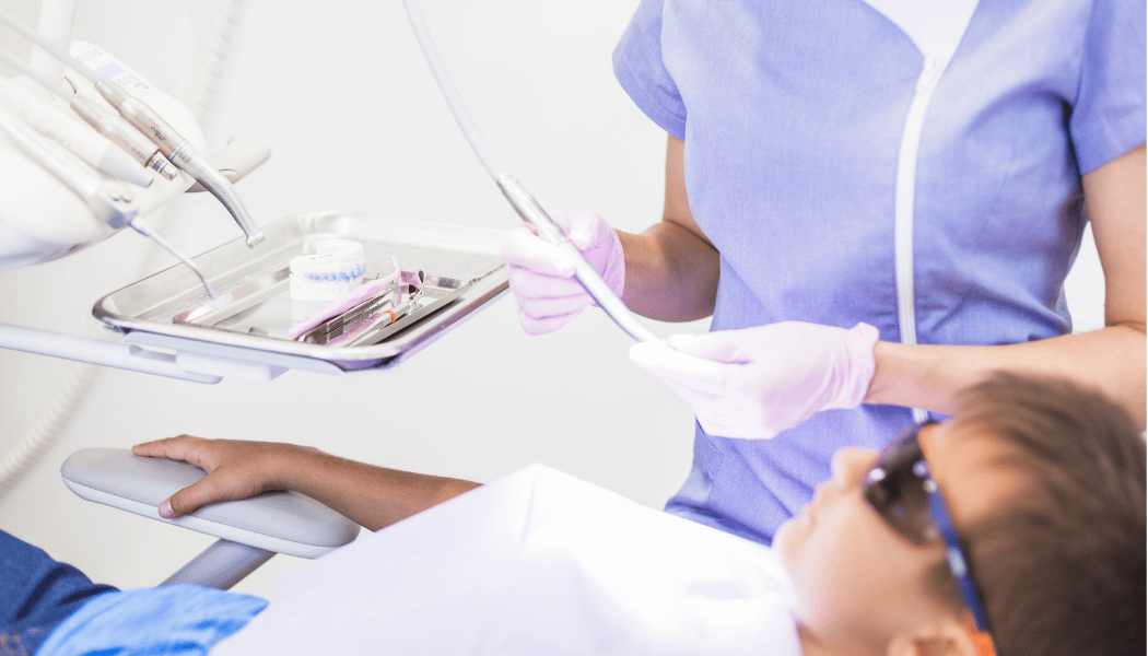 child at the dentist during the summer receiving dental care