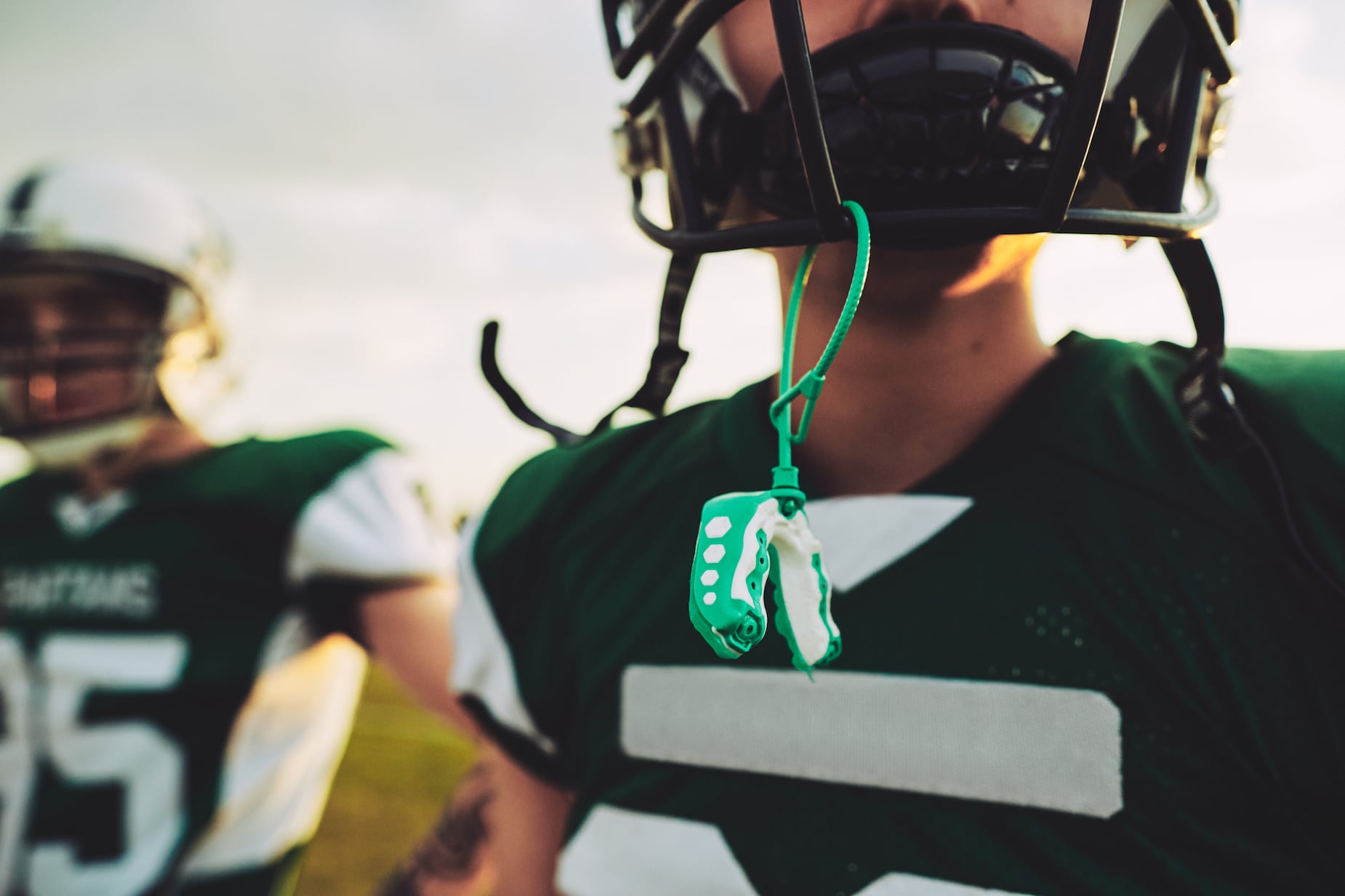 young football player with helmet and mouthguard - header for National Facial Protection Month Blog